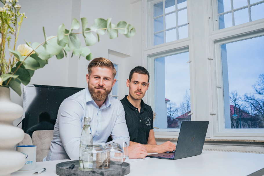Mitarbeiter des Unternehmens sitzen am Tisch und arbeiten am Laptop.