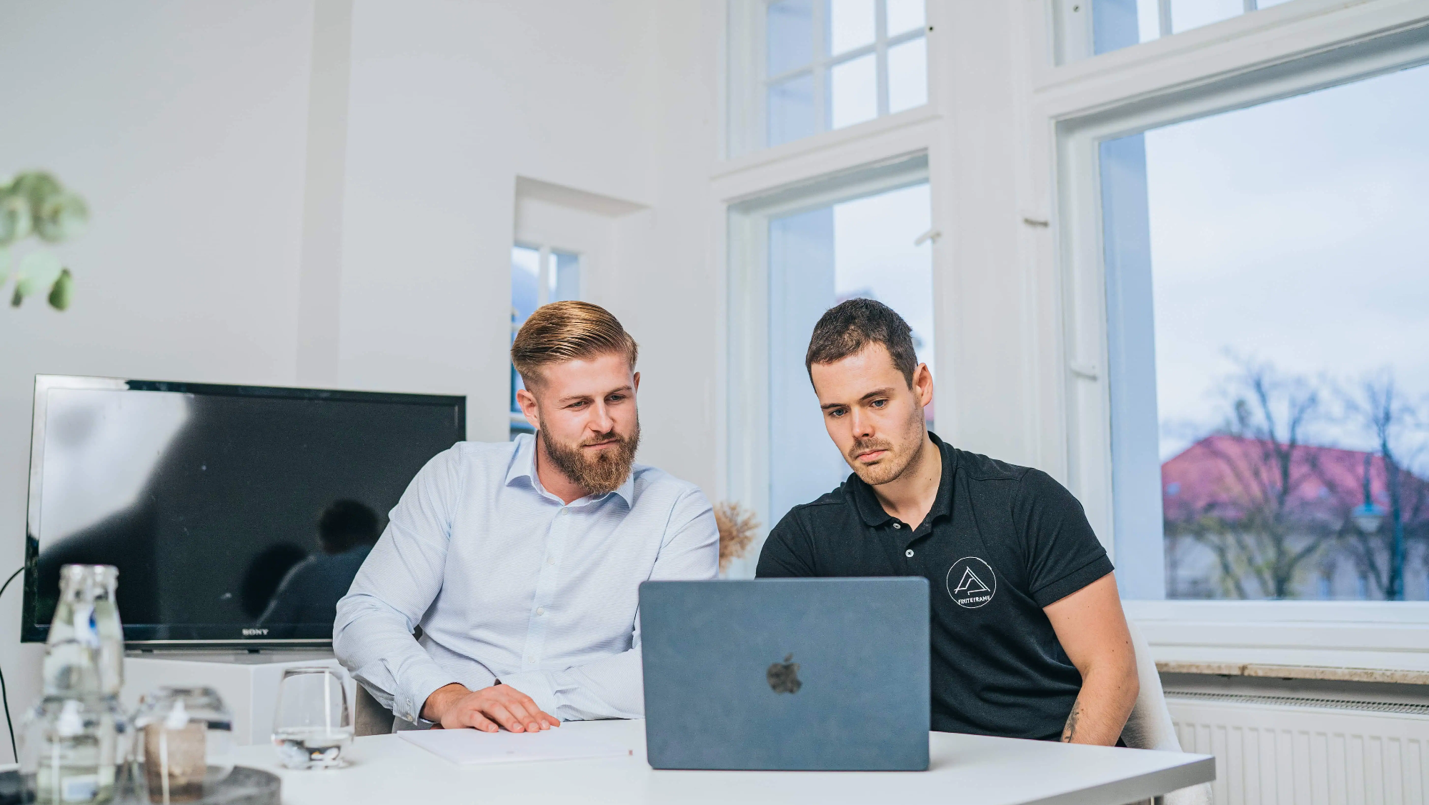 Zwei Ingenieure sitzen vor dem Laptop und planen ein Projekt.